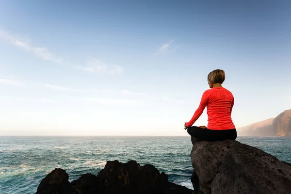 Donna che medita in posa yoga, vista sull'oceano — Foto Stock