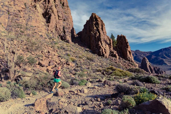 Жінка біжить в горах на скелястій стежці — стокове фото