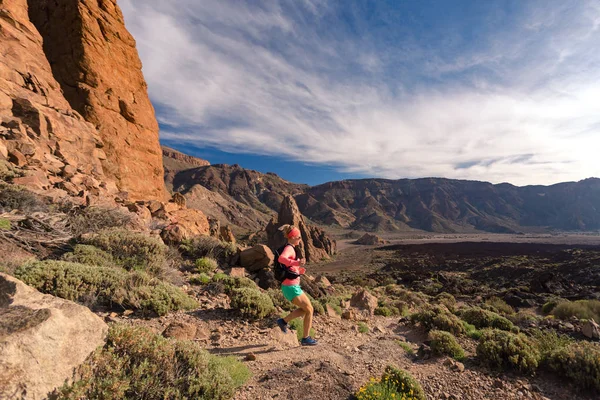 Atravesse o país correndo com mochila em montanhas em trilha rochosa — Fotografia de Stock
