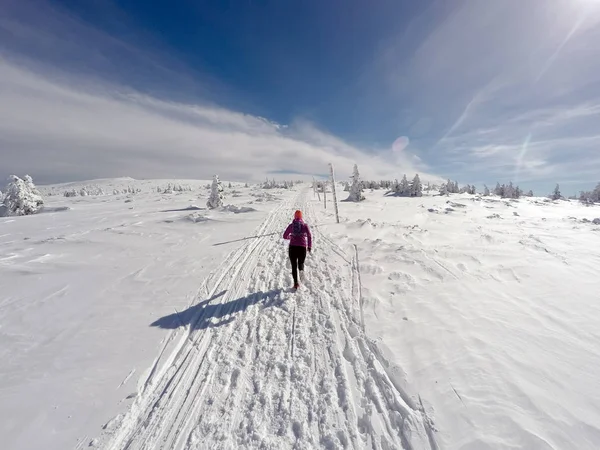 Mulher correndo em trilha de inverno, neve e montanhas brancas — Fotografia de Stock
