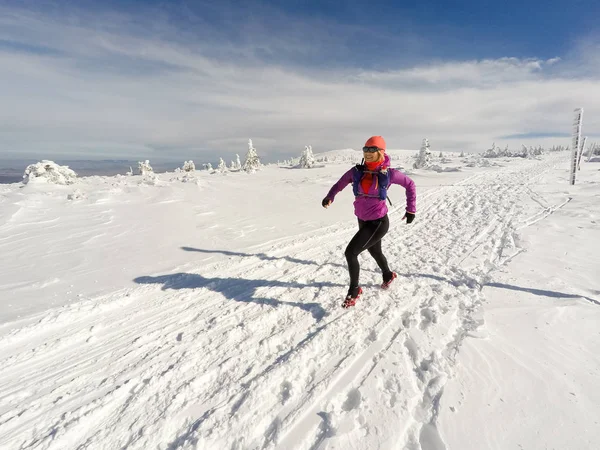 Running vrouw op winter trail, de sneeuw en de witte bergen — Stockfoto