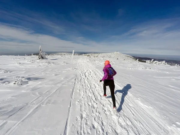 Mulher correndo em trilha de inverno, neve e montanhas brancas — Fotografia de Stock