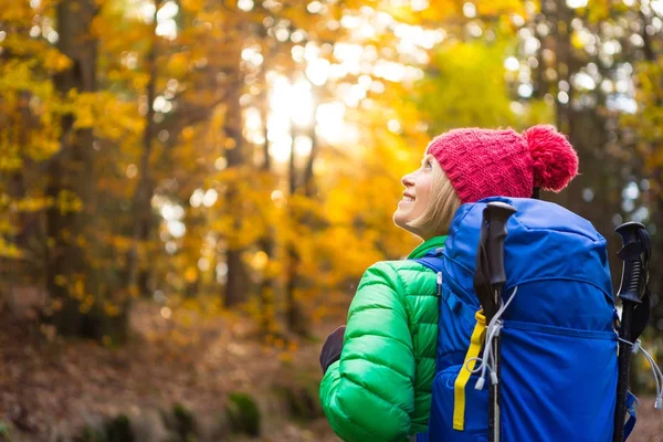 Mulher caminhando com mochila olhando para inspirador ouro do outono — Fotografia de Stock