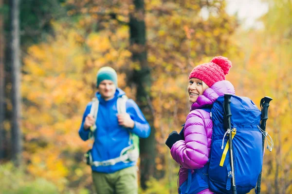 男と女の幸せなカップル ハイカーが秋の森を歩いて — ストック写真