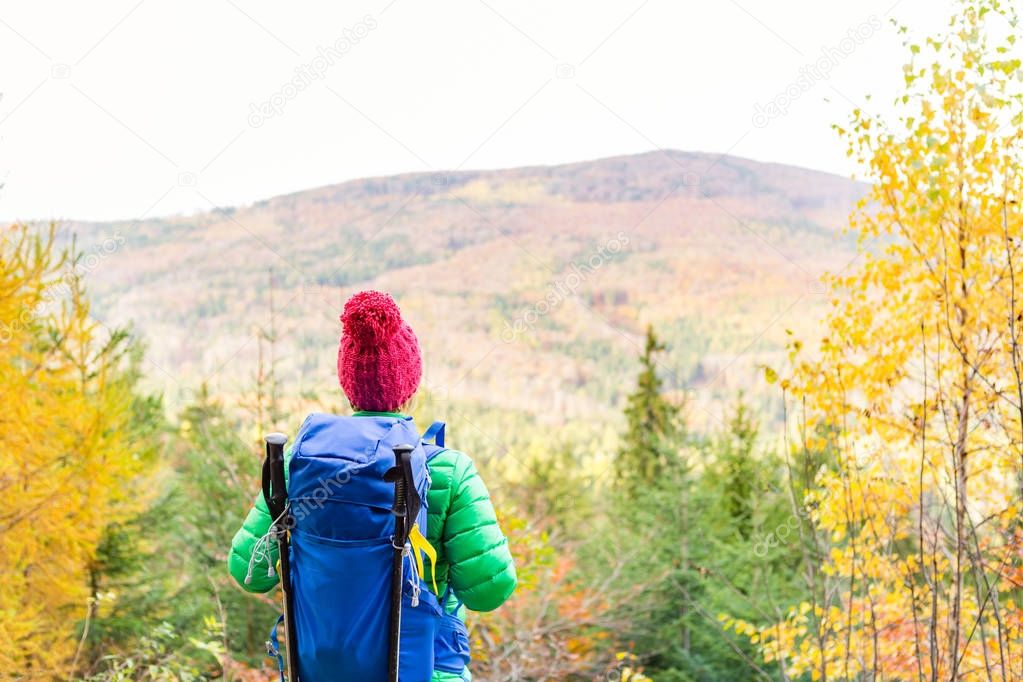 Hiking woman with backpack looking at inspirational autumn gold