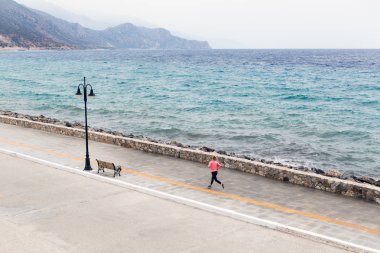 Deniz kenarında caddenin üzerinde çalışan kadın