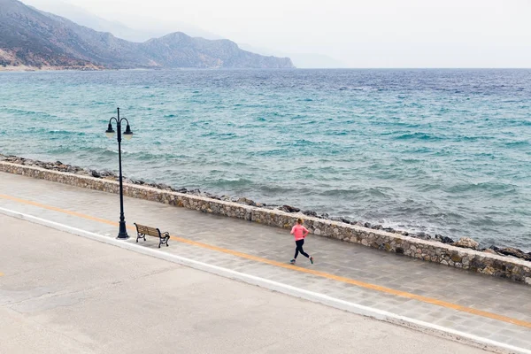Γυναίκα τρέχει στο δρόμο στην παραλία της πόλης — Φωτογραφία Αρχείου