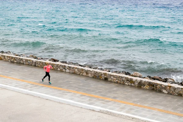 Donna che corre sulla strada della città al mare — Foto Stock