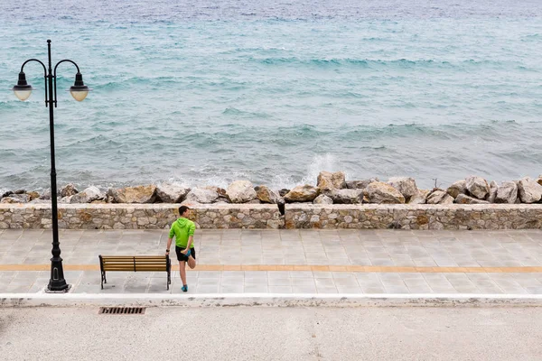 Egzersiz ve deniz kenarında caddenin üzerinde çalışan adam — Stok fotoğraf