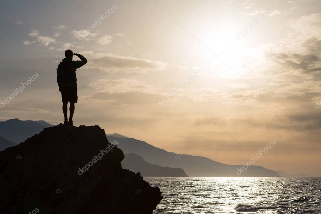 Hiking silhouette backpacker, man looking at ocean