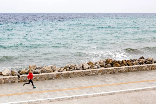 Kvinna som jogging på ort gata på seaside — Stockfoto