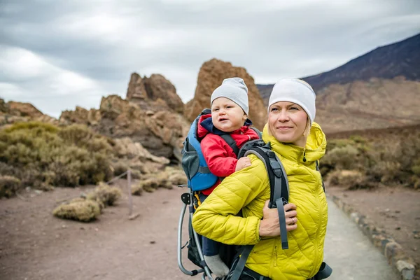 Super mamma med baby boy vandring i ryggsäck — Stockfoto
