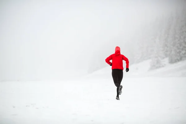 Trail running woman in winter mountains — Stock Photo, Image