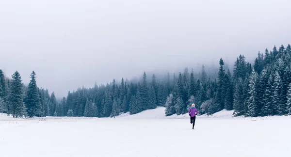 Mujer corriendo en el sendero de invierno en el bosque, inspiración fitness —  Fotos de Stock