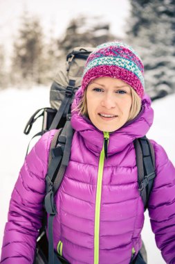 Kadın sırt çantası ile beyaz kış orman ormanda hiking. Rekreasyon fitness ve sağlıklı yaşam tarzı açık havada doğa, açık havada kamp. Motivasyon ve ilham verici kış manzarası.