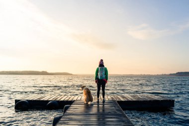 Kadın ile köpek zevk gündoğumu gölde, backpacker