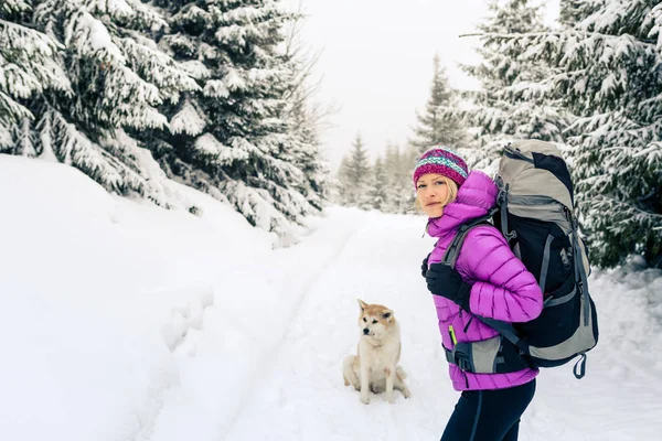 Happy woman walking in winter forest with dog — Stock Photo, Image