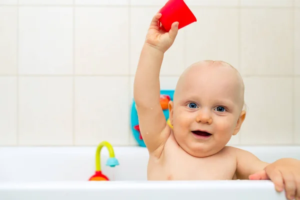 Baby pojke tar ett bad, spela i ett badkar — Stockfoto