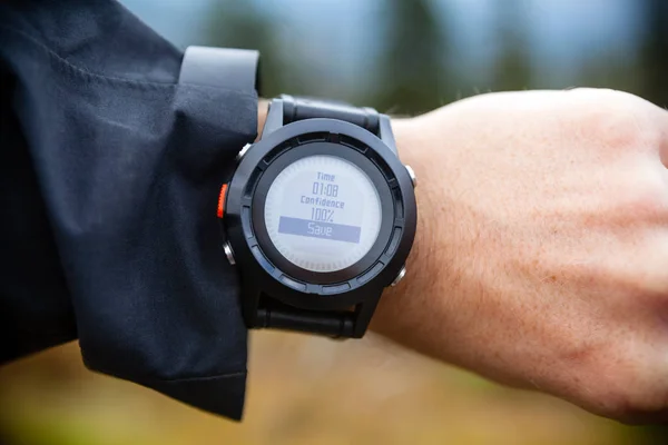 Hiker on mountain trail checking compass, wearable technology — Stock Photo, Image