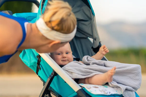 Bebek arabasındaki bebek annelik günbatımı toprakları, zevk ile anne — Stok fotoğraf