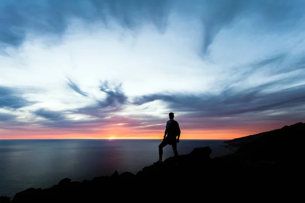 Celebrating or meditating man looking at sunset ocean — Stock Photo, Image