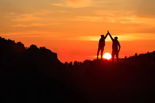 Pareja de trabajo en equipo celebrando en inspiradoras montañas la puesta del sol —  Fotos de Stock