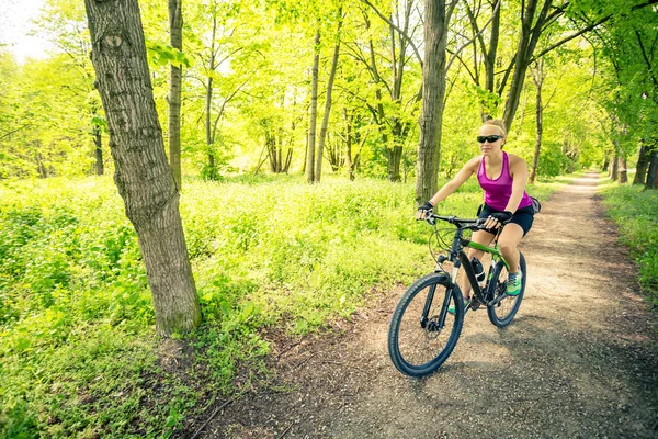 Mulher de bicicleta de montanha no parque da cidade, dia de verão — Fotografia de Stock