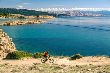 Manzaraya bakarak ve yaz deniz manzara modunda bisikletle seyahat Mountainbiker. Adam binici MTB kayalık sarı yolda Bisiklete binme. Fitness motivasyon, güzel ilham verici manzara ilham.