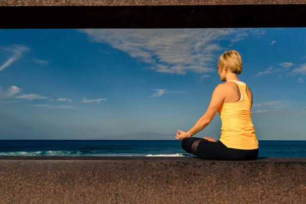 Йога дівчата медитації та релаксації у йоги пози, видом на океан — стокове фото