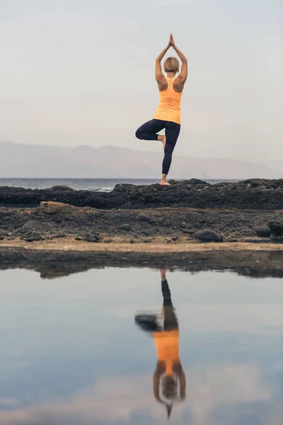 Ragazza di yoga meditare e rilassarsi in posa yoga, vista sull'oceano — Foto Stock