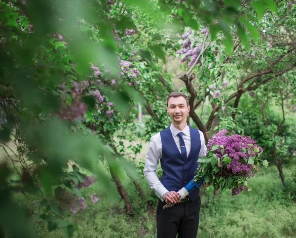 Novio guapo con ramo de lilas — Foto de Stock