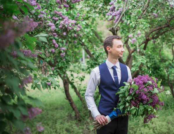 Bello sposo con bouquet di lilla — Foto Stock