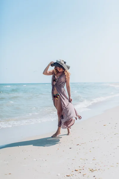 Mujer en la arena en la orilla del mar —  Fotos de Stock