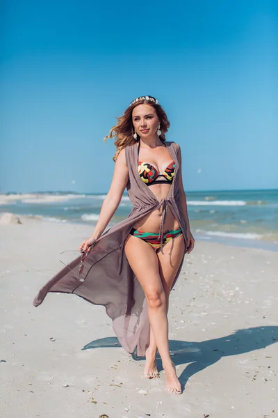 Vrouw op het zand aan de kust — Stockfoto