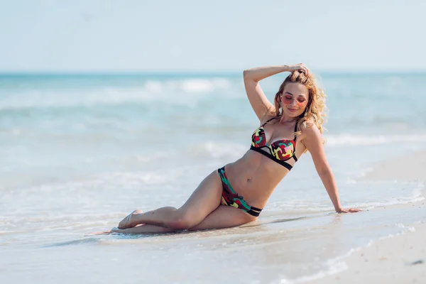 Mujer en la arena en la orilla del mar —  Fotos de Stock