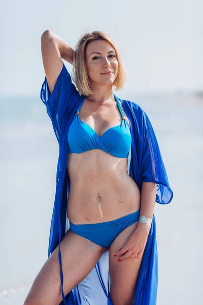 Blondi nainen meren rannalla — kuvapankkivalokuva