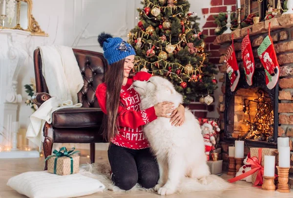 Kvinna nära julgranen med samojedvalpar hund — Stockfoto
