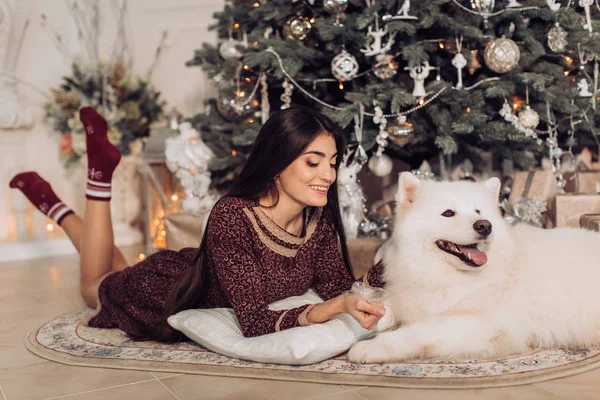 サモエド犬とクリスマス ツリーの近くの女性 — ストック写真