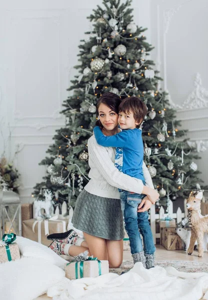 Moeder en zoon in de buurt van de kerstboom — Stockfoto