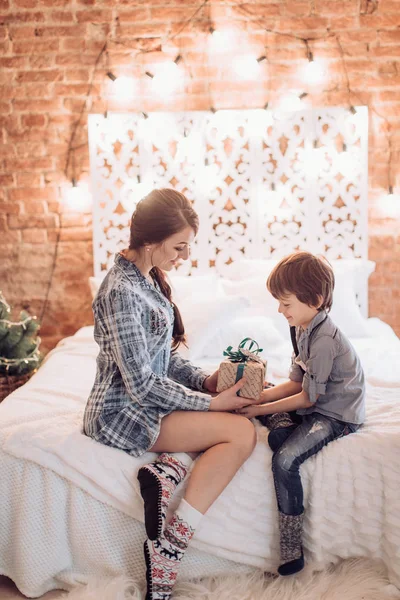 Madre dando regalo de Navidad a su hijo —  Fotos de Stock