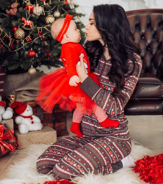 Baby flicka och mor nära julgran — Stockfoto