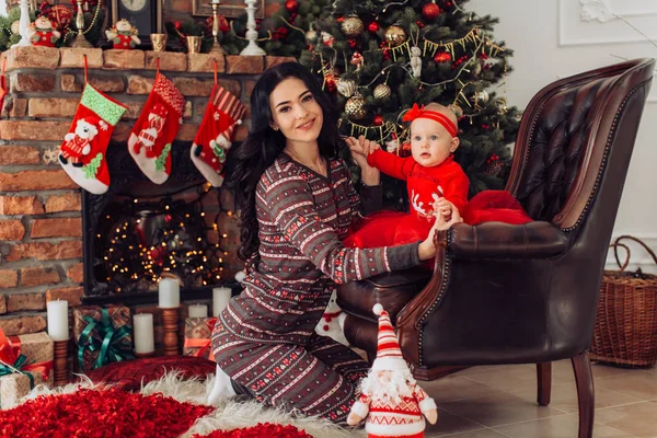 Meisje van de baby en de moeder in de buurt van de kerstboom — Stockfoto