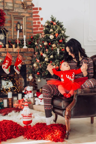 Baby flicka och mor nära julgran — Stockfoto