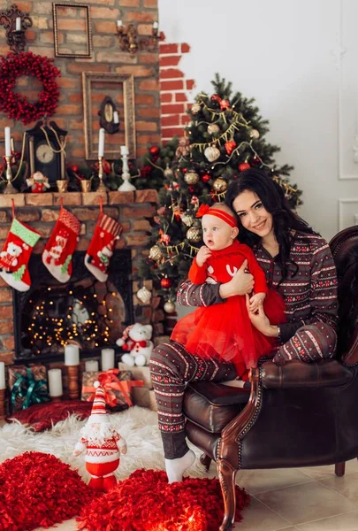 Meisje van de baby en de moeder in de buurt van de kerstboom — Stockfoto