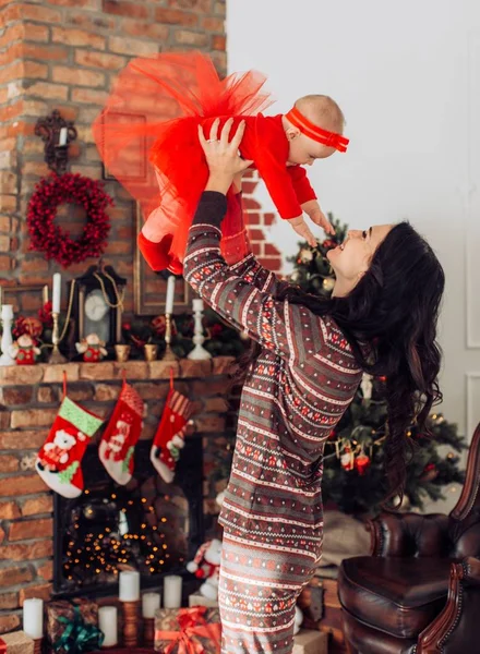 Meisje van de baby en de moeder in de buurt van de kerstboom — Stockfoto
