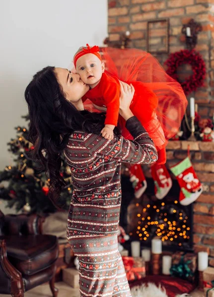 Baby flicka och mor nära julgran — Stockfoto