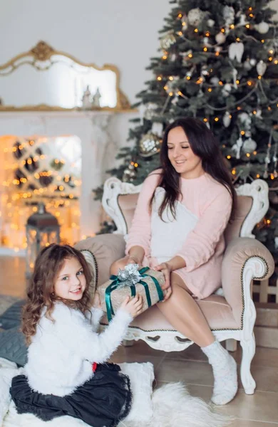 女の子とクリスマス ツリーの近くの母 — ストック写真