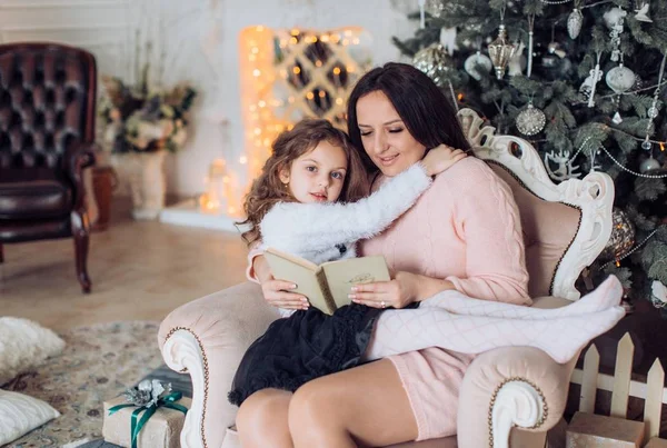 Meisje en moeder in de buurt van de kerstboom — Stockfoto
