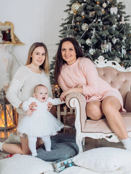 Meisje en ouders in de buurt van de kerstboom — Stockfoto