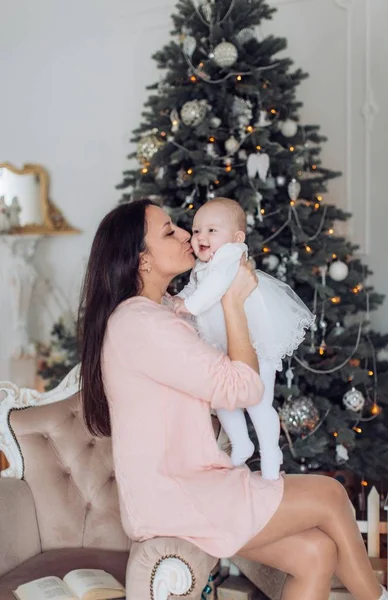 Meisje en moeder in de buurt van de kerstboom — Stockfoto